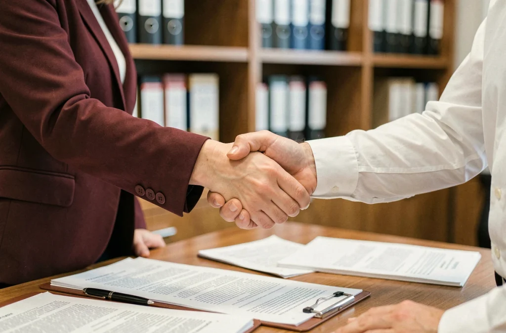 Poignée de main entre deux partenaires commerciaux après la résolution réussie d'un litige par médiation